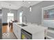 Modern kitchen with white cabinets, stainless steel appliances, a large island with seating and hardwood floors at 46 N Denny St, Indianapolis, IN 46201