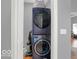 A modern, stacked washer and dryer sit inside of the home's laundry area near an open doorway at 46 N Denny St, Indianapolis, IN 46201