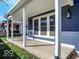 Spacious porch featuring a view of the surrounding neighborhood, sturdy white columns, and dark blue siding at 46 N Denny St, Indianapolis, IN 46201