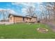 Expansive backyard featuring a brick patio, lush lawn, fire pit, and mature trees, perfect for outdoor living at 516 Hanover Dr, Anderson, IN 46012