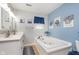 Well-lit bathroom featuring a large soaking tub, double sinks, updated fixtures, and ceramic tile at 516 Hanover Dr, Anderson, IN 46012