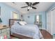 This bedroom boasts a modern ceiling fan, updated fixtures, hardwood floors, and large windows at 516 Hanover Dr, Anderson, IN 46012