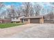 Split-level home with attached garage, spacious driveway, and large gravel parking area at 516 Hanover Dr, Anderson, IN 46012