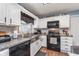 Updated kitchen features white cabinets, stainless sink, and gas range at 516 Hanover Dr, Anderson, IN 46012