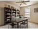 Home office with a large built-in bookcase, a table with chairs, and a ceiling fan for comfort at 5387 Crowley Pkwy, Whitestown, IN 46075