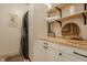 Efficient laundry room featuring a stacked washer/dryer unit, white cabinets, wood countertop, and open shelving at 5387 Crowley Pkwy, Whitestown, IN 46075