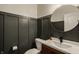Stylish powder room with dark wainscoting, a round mirror, modern sink, and sleek fixtures at 5387 Crowley Pkwy, Whitestown, IN 46075
