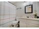 Bright bathroom with a striped shower curtain, white cabinets, and vinyl flooring at 5541 Fair Ridge Pl, Indianapolis, IN 46221