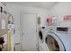 Laundry room with washer, dryer, and shelving at 5541 Fair Ridge Pl, Indianapolis, IN 46221