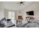 Bright living room features a fireplace, ceiling fan, modern flooring, and access to the backyard at 5541 Fair Ridge Pl, Indianapolis, IN 46221