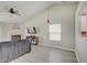Bright living room features a fireplace, ceiling fan, modern flooring, and a vaulted ceiling at 5541 Fair Ridge Pl, Indianapolis, IN 46221