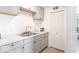 Kitchen features gray cabinets, white countertops, microwave and double bowl sink at 555 Leeds Ave, Indianapolis, IN 46203