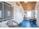 Bright sun room with wood ceiling, blue floors, and ample light from large windows at 555 Leeds Ave, Indianapolis, IN 46203