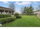 Well-manicured backyard showcasing lush lawn, mature trees, and a charming screened-in porch at 5710 Dapple Trce, Indianapolis, IN 46228