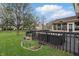 Spacious backyard featuring a deck, outdoor seating, lush green grass, and a blooming tree at 5710 Dapple Trce, Indianapolis, IN 46228