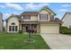 Classic two-story house featuring a manicured lawn, attached garage, and inviting entrance with a lamppost at 5710 Dapple Trce, Indianapolis, IN 46228