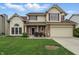 Charming two-story home with a well-manicured lawn, attached garage, and inviting front porch at 5710 Dapple Trce, Indianapolis, IN 46228