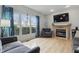 Cozy living room featuring modern gas fireplace, flat screen TV, large windows, and hardwood flooring at 5710 Dapple Trce, Indianapolis, IN 46228