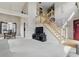 Spacious living room featuring staircase, large windows, neutral walls, and access to the dining room at 5710 Dapple Trce, Indianapolis, IN 46228
