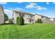 The grassy backyard features a home with a patio, green bushes, and a blue sky with white clouds at 5861 W Deerview Bnd, McCordsville, IN 46055