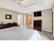 Main bedroom with a tray ceiling, TV, and en suite bathroom entrance at 5861 W Deerview Bnd, McCordsville, IN 46055