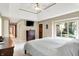 Main bedroom with a tray ceiling, TV, and large window overlooking the backyard at 5861 W Deerview Bnd, McCordsville, IN 46055