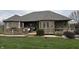 An outdoor wooden deck features comfortable seating, an umbrella, and a relaxing space adjacent to the house at 6089 W Hellis Dr, Muncie, IN 47304