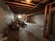 Unfinished basement with exposed wood beams, concrete floor, and white cinder block walls at 6089 W Hellis Dr, Muncie, IN 47304