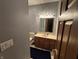 This full bathroom has a dark wood vanity with sink, mirror with light fixture, toilet, and dark rug at 6089 W Hellis Dr, Muncie, IN 47304