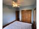 This blue bedroom has wood floors, ceiling fan, closet with bi-fold doors, and a full size bed at 6089 W Hellis Dr, Muncie, IN 47304