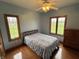A bright bedroom with two large windows, wood floors, a full size bed, and a wood dresser at 6089 W Hellis Dr, Muncie, IN 47304