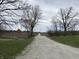 Gravel road leading to the distance surrounded by trees. A No Outlet sign is visible at 6089 W Hellis Dr, Muncie, IN 47304