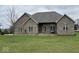 Charming brick home with manicured lawn and inviting front porch seating at 6089 W Hellis Dr, Muncie, IN 47304