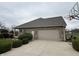 Brick two-car garage features a basketball hoop and landscaping, showcasing functionality and curb appeal at 6089 W Hellis Dr, Muncie, IN 47304