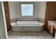 Spa-like main bath with soaking tub and tile surround at 6089 W Hellis Dr, Muncie, IN 47304