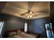 A nicely finished main bedroom with tray ceiling, fan and light fixture, and a comfortable king bed at 6089 W Hellis Dr, Muncie, IN 47304