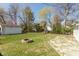 Backyard featuring a fire pit, detached garage and plenty of trees at 6120 Norwaldo Ave, Indianapolis, IN 46220