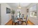 Bright dining room with hardwood floors, a modern chandelier, and a glass-top dining table at 6120 Norwaldo Ave, Indianapolis, IN 46220