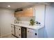 Finished basement featuring custom cabinetry, sink, marble countertop, and beverage refrigerator at 619 Kessler Blvd E Dr, Indianapolis, IN 46220