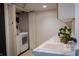 Bright laundry room featuring open folding doors, white counter, and wash sink at 619 Kessler Blvd E Dr, Indianapolis, IN 46220