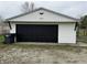 Detached garage featuring a black door and white siding at 6431 W 800 S, Pendleton, IN 46064