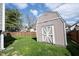 View of the wooden shed and spacious green backyard in a fenced in area on a sunny day at 726 Westridge S Dr, Noblesville, IN 46062