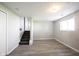 Open basement featuring modern gray flooring, access to stairs, and natural light from the window at 726 Westridge S Dr, Noblesville, IN 46062