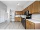 Open kitchen featuring stainless steel appliances, light wood cabinets, and vinyl flooring at 726 Westridge S Dr, Noblesville, IN 46062