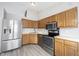 Bright kitchen with stainless steel appliances, wood cabinets, and vinyl flooring at 726 Westridge S Dr, Noblesville, IN 46062