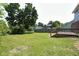 Expansive backyard with a lush lawn, mature trees, and a wooden deck, perfect for outdoor entertaining at 7421 Rogers Dr, Indianapolis, IN 46214