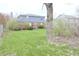 View of the backyard featuring mature trees and partially fenced yard at 7421 Rogers Dr, Indianapolis, IN 46214
