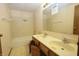 Bathroom with tile shower, double sink vanity, and an open cabinet revealing storage space at 7421 Rogers Dr, Indianapolis, IN 46214