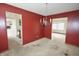 Dining room with red walls and an ornate chandelier, with access to other rooms at 7421 Rogers Dr, Indianapolis, IN 46214