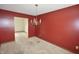 Dining room with chandelier, red walls, and entrance to another room at 7421 Rogers Dr, Indianapolis, IN 46214